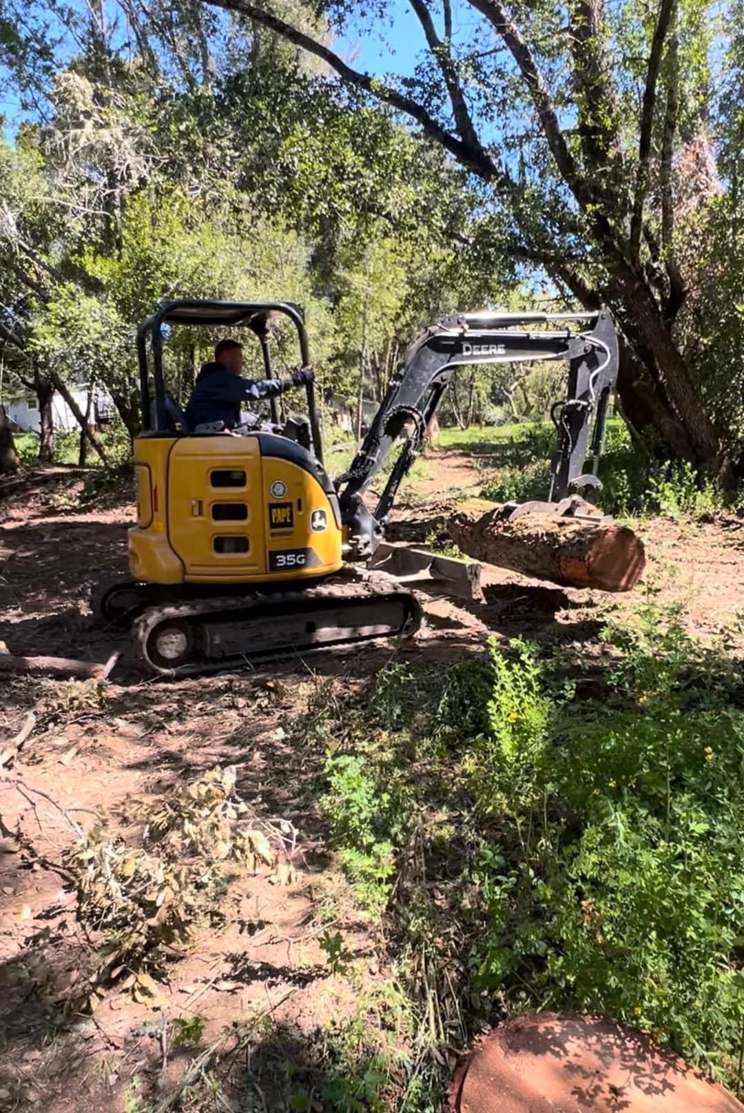 picture of an excavator excavating dirt and debree and brush